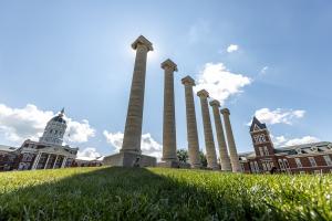 Photo of the Columns at the University of Missouri with blue sky behind them.
