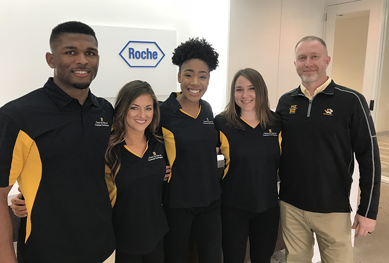 Mizzou students and faculty in front of Roche sign.